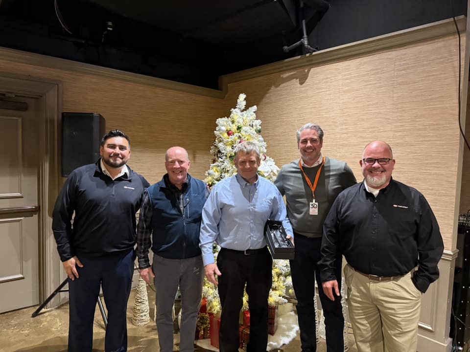 Group photo including (left to right) Jose Villarreal, Jeff Betzoldt, Doug Adams, Mike Sausman, and Tom Cain with Doug holding his engraved crystal leadership award